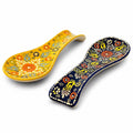 Two hand-painted floral ceramic spoon rests in yellow and dark blue