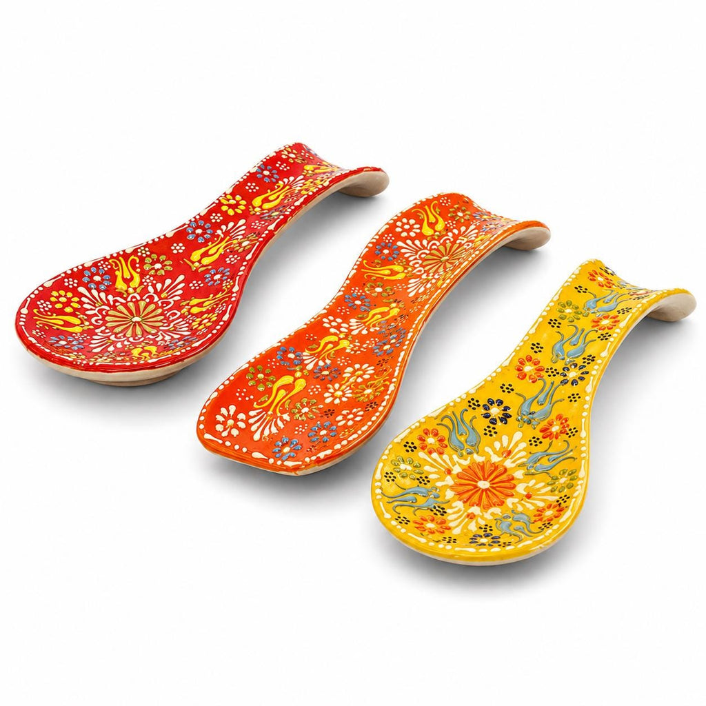 Three warm-color hand-painted floral ceramic spoon rests