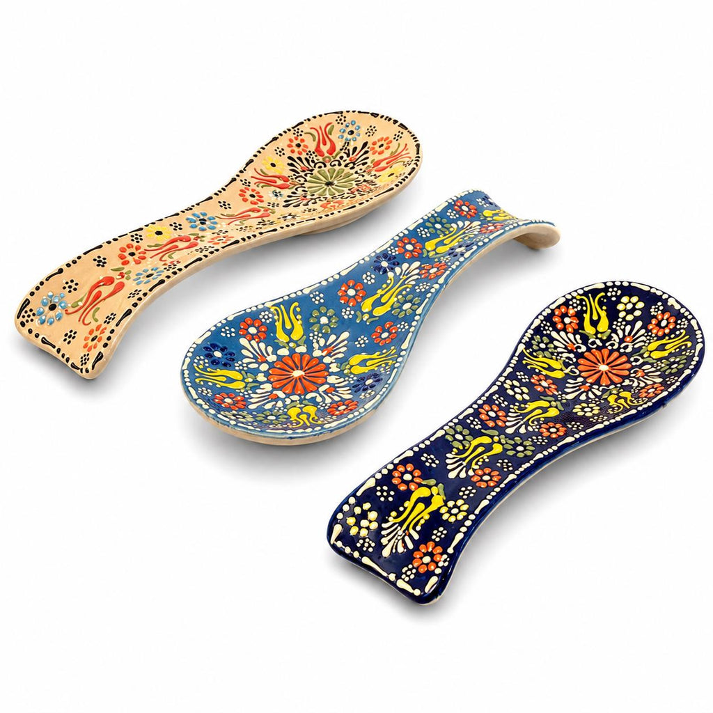 Three hand-painted floral ceramic spoon rests in assorted colors