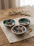 Set of three hand-painted ceramic bowls with a small serving spoon