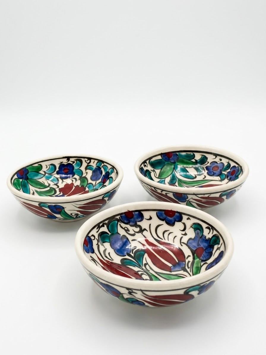 Three hand-painted floral ceramic bowls viewed together