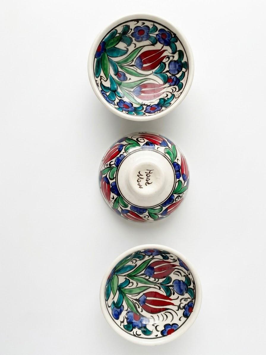 Three floral ceramic bowls with one bowl showing its handmade underside